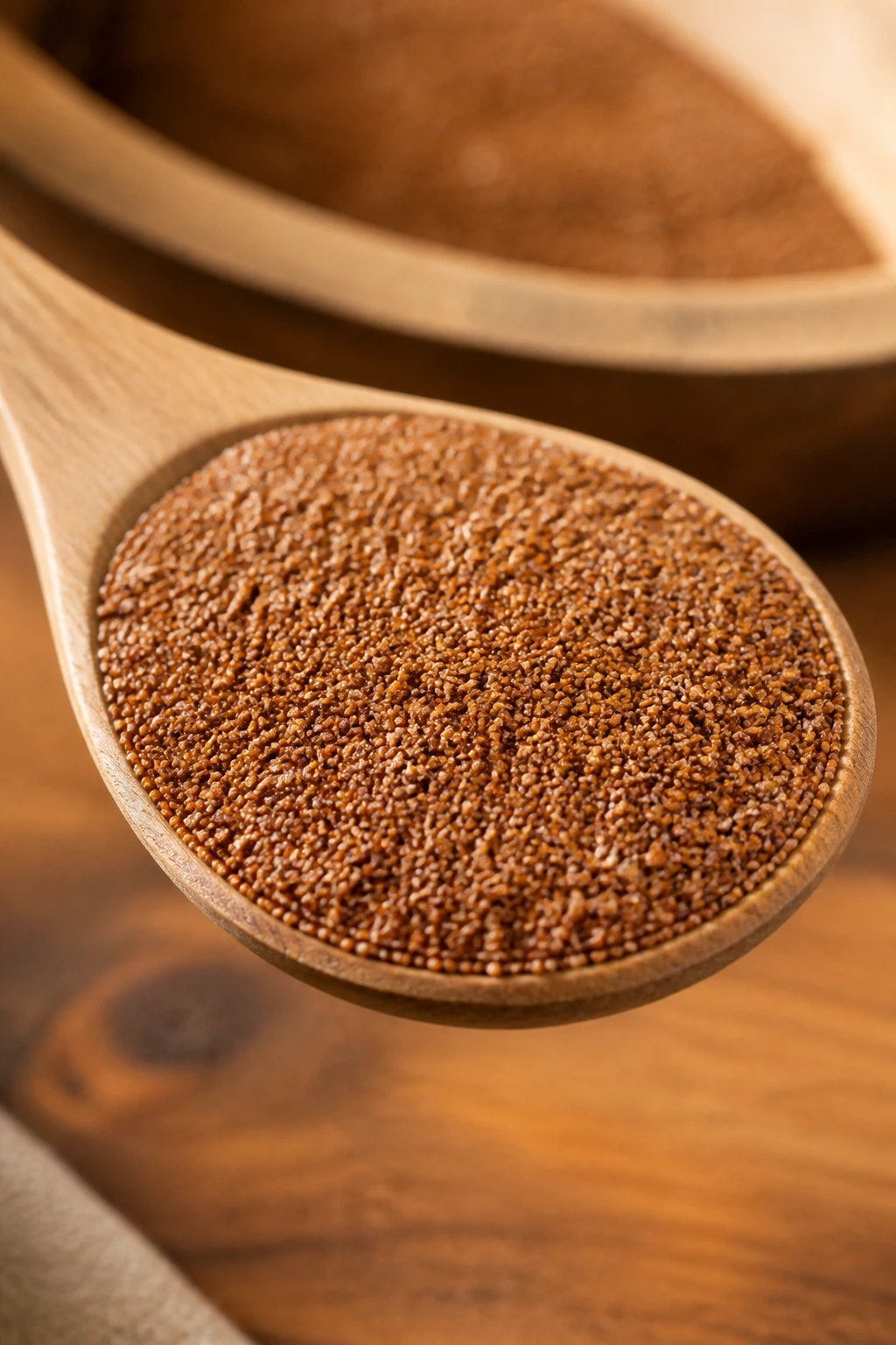 Tiny teff grains on a wooden spoon, macro shot